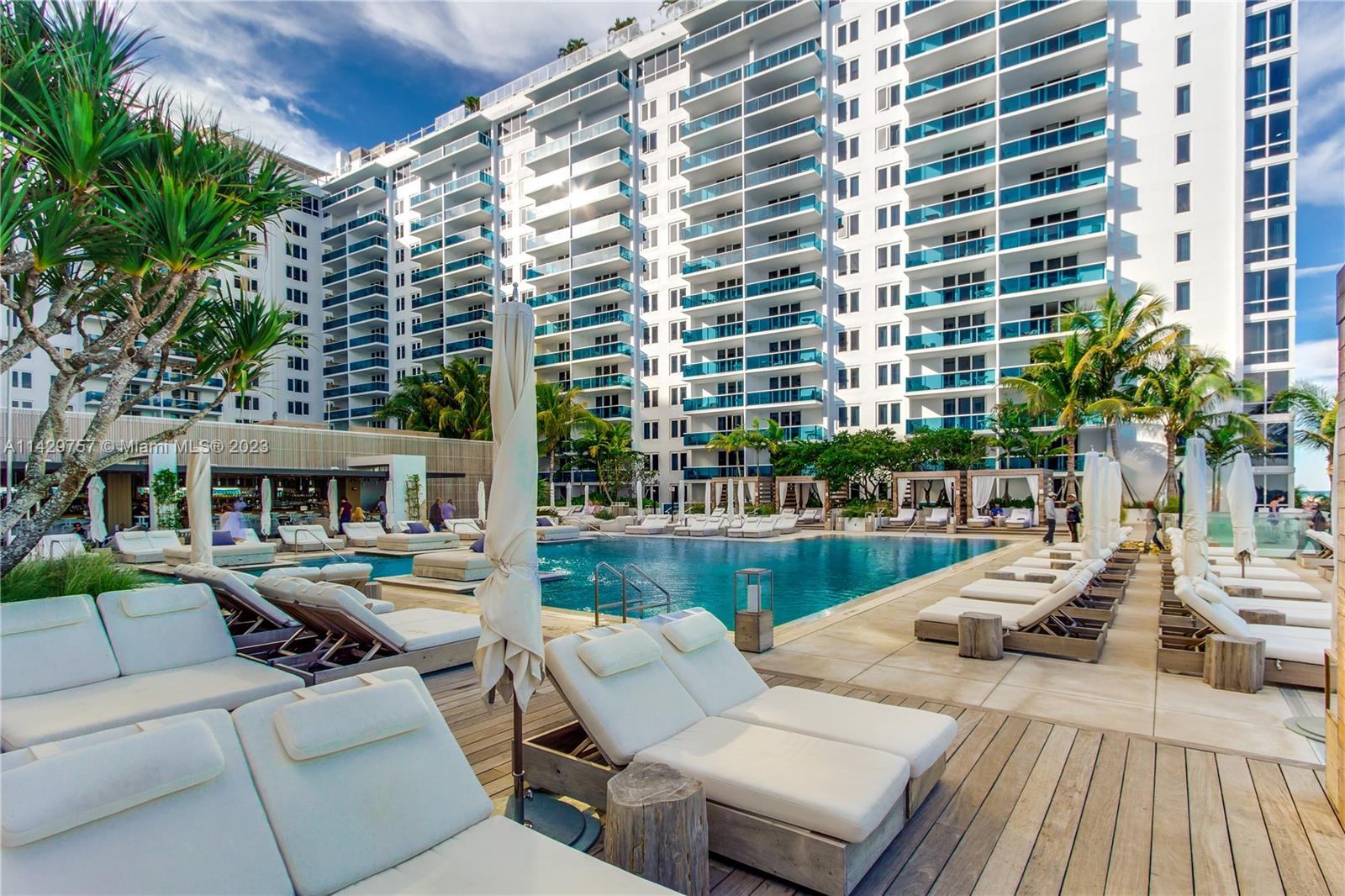 102 24th Street, Unit 1013 Miami Beach, FL 33139 - Photo 8 of 38 a view of a patio with couches and table and chairs with wooden floor and plants