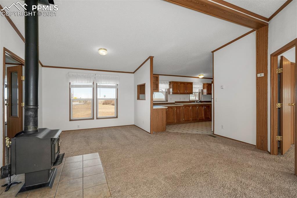4270 Oil Well Road Yoder, CO 80864 - Photo 14 of 42 The french doors next to the stove open to the office. The additional bedrooms and bath are down the hall.