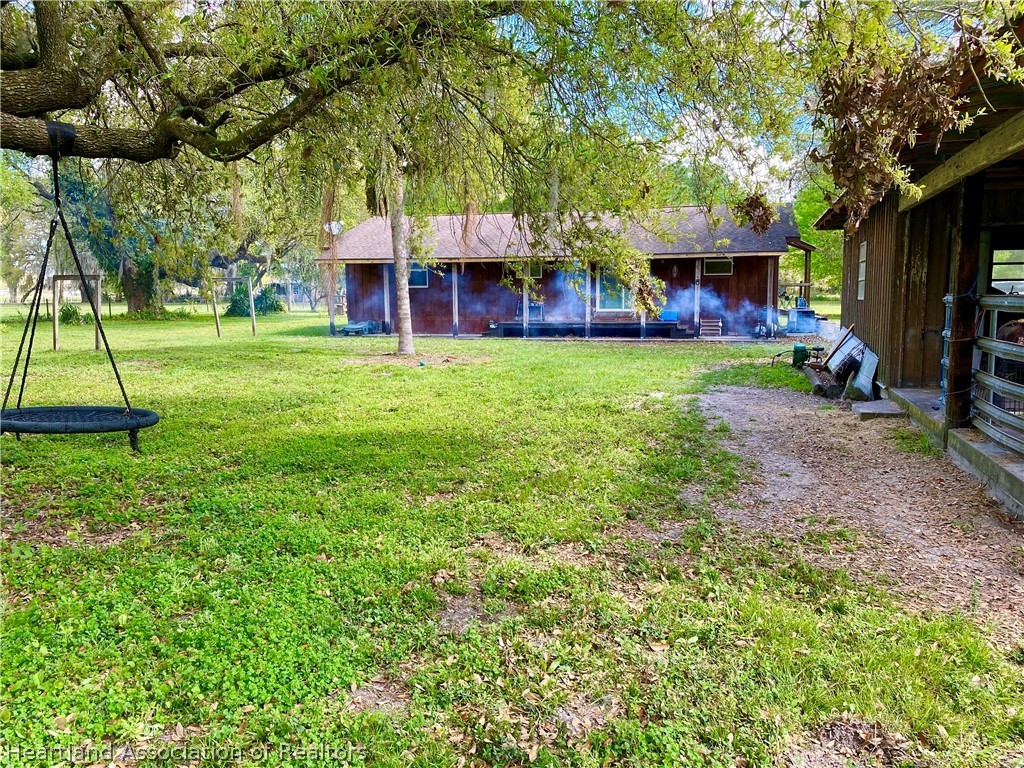 538 Hayman Road Wauchula, FL 33873 - Photo 7 of 21 a view of a house with a backyard and a patio