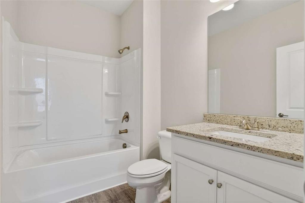 3405 Ripple Loop, Unit 127 South Fulton, GA 30349 - Photo 19 of 26 a bathroom with a granite countertop sink toilet mirror vanity and bathtub