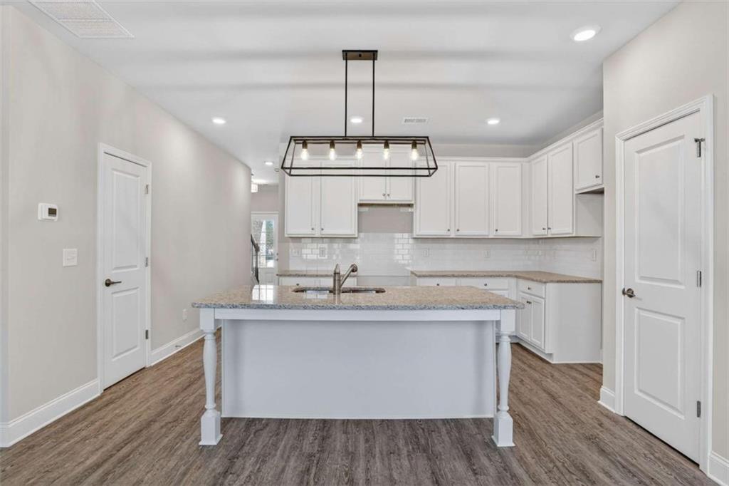 3405 Ripple Loop, Unit 127 South Fulton, GA 30349 - Photo 6 of 26 a kitchen with kitchen island granite countertop a sink cabinets and wooden floor