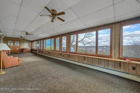 a view of a hallway with wooden floor and windows