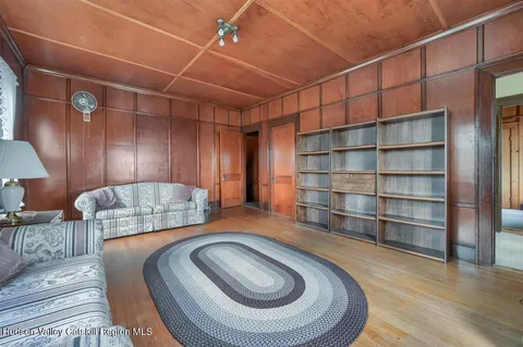 a view of a hallway with wooden floor and stairs