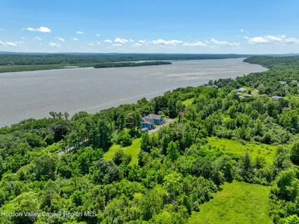 an aerial view of a house with a yard and lake view