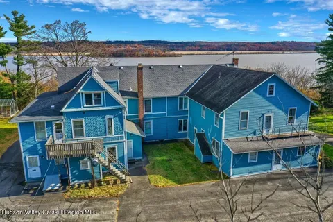 an aerial view of a house with a yard and lake view