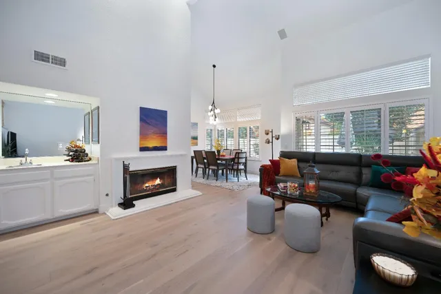 a living room with furniture a fireplace and a large window