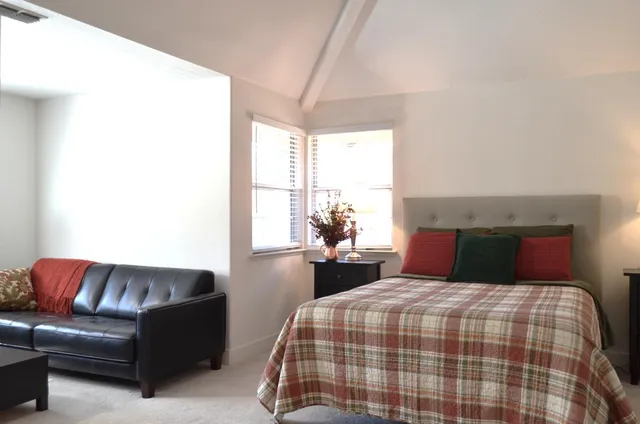 a bedroom with a large bed and a couch