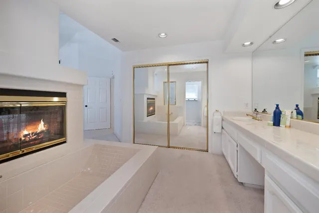 a spacious bathroom with a granite countertop sink a toilet a shower and a mirror