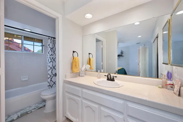 a bathroom with a double vanity sink toilet and shower