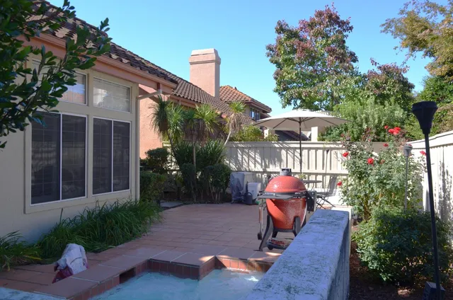 a view of a chair and table in backyard of the house