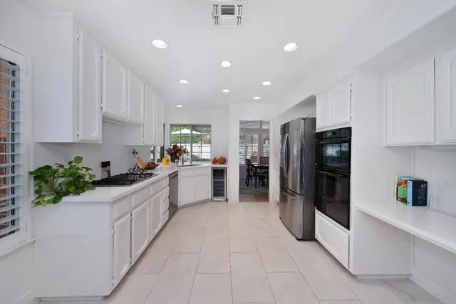a kitchen with stainless steel appliances kitchen island granite countertop a refrigerator and a sink