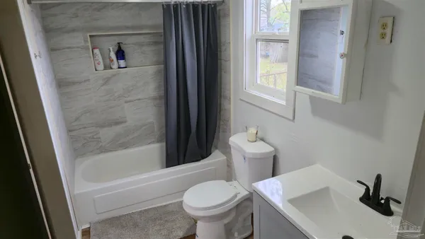 a white toilet sitting next to a bath tub