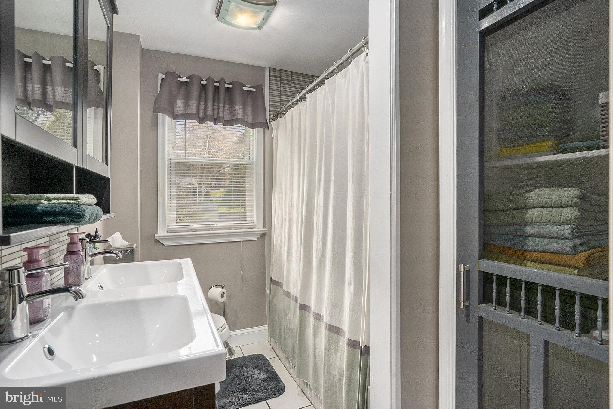 1271 Phoenixville Pike West Chester, PA 19380 - Photo 19 of 33 a bathroom with a sink a mirror and next to a window