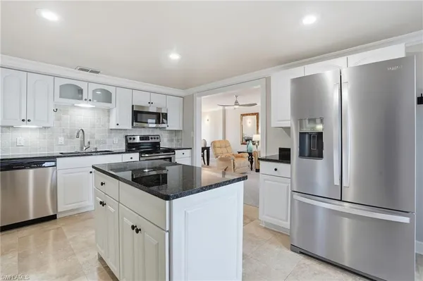 a kitchen with white cabinets and stainless steel appliances