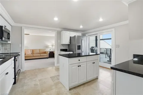 a kitchen with granite countertop a sink and a refrigerator