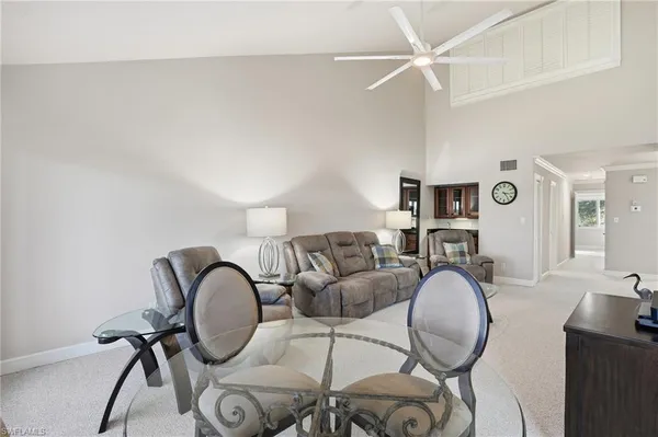 a living room with furniture a rug and white walls
