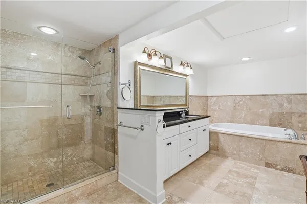 a bathroom with a granite countertop sink and a bathtub
