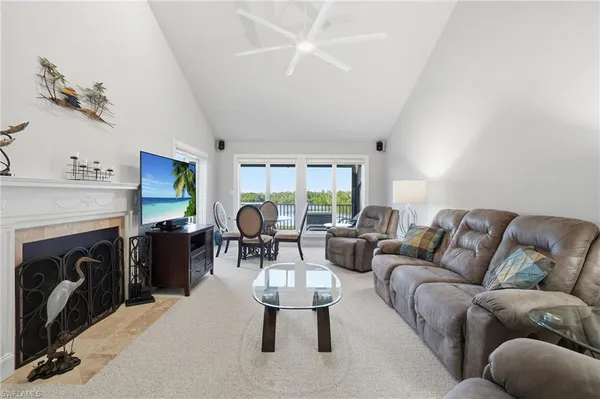 a living room with furniture a fireplace and a large window