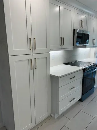 a kitchen with stainless steel appliances white cabinets and a sink