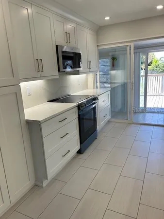 a large kitchen with a stove a sink and a microwave