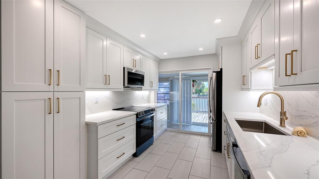 100 Bayshore Road, Unit C Nokomis, FL 34275 - Photo 14 of 39 a kitchen with stainless steel appliances granite countertop a sink a stove and a refrigerator