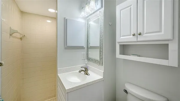 a bathroom with a sink a toilet and shower