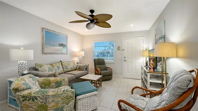 a living room with furniture a lamp and a ceiling fan