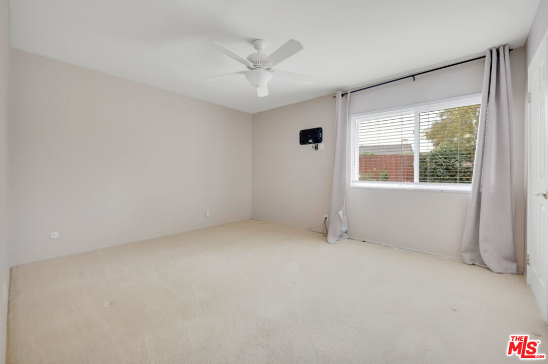 13480 Laurelhurst Road Moorpark, CA 93021 - Photo 16 of 34 an empty room with a ceiling fan and windows