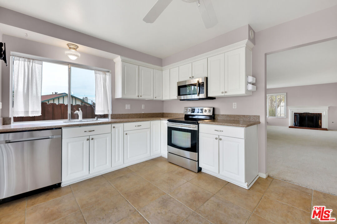 13480 Laurelhurst Road Moorpark, CA 93021 - Photo 9 of 34 a kitchen with white cabinets and white appliances