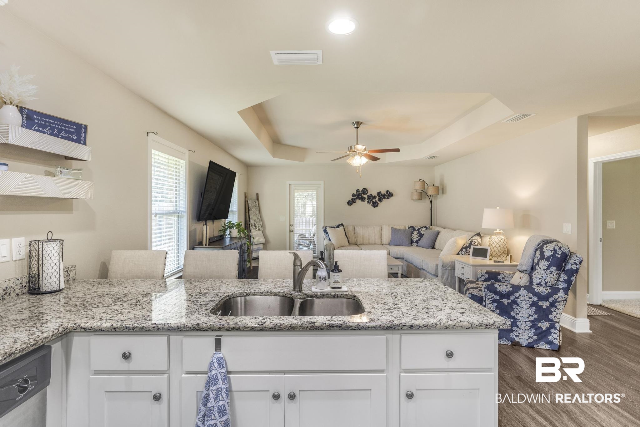 22043 Garland Loop Silverhill, AL 36576 - Photo 40 of 41 Kitchen featuring open floor plan, a peninsula, a ceiling fan, light stone counters, and a tray ceiling