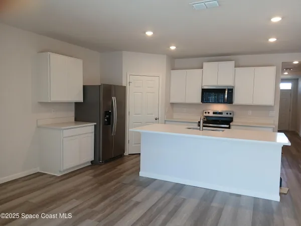 a kitchen with a refrigerator a stove top oven a sink and dishwasher