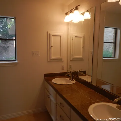 a bathroom with a granite countertop sink and a mirror