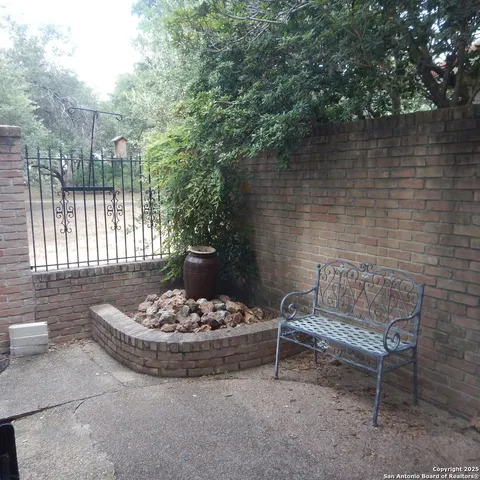 a backyard of a house with potted plants and large trees