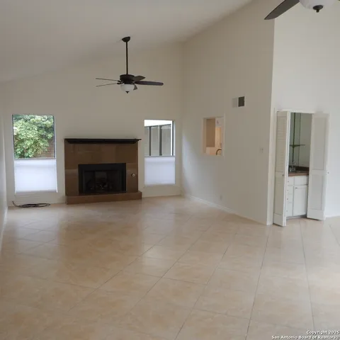 an empty room with windows and fireplace