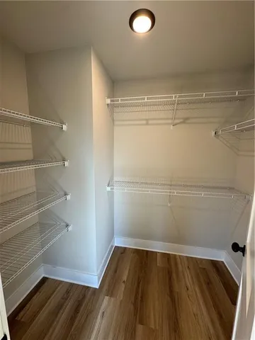 a view of walk in closet with empty racks