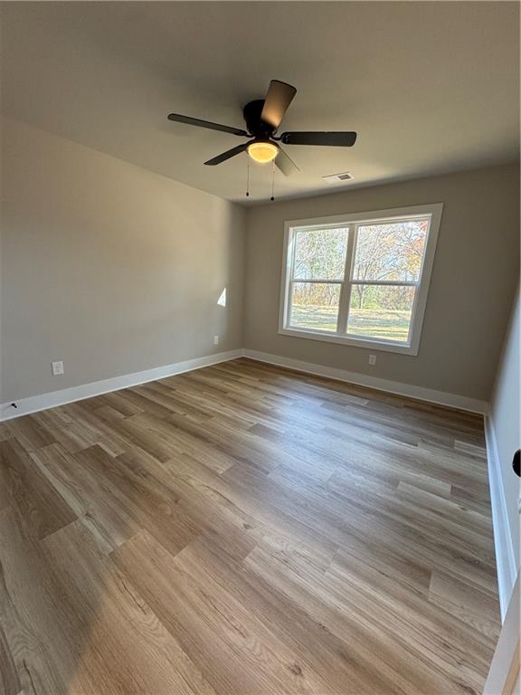 1612 Pickens Street Ball Ground, GA 30107 - Photo 29 of 53 an empty room with wooden floor ceiling fan and windows