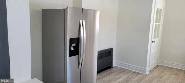 a view of kitchen with stainless steel appliances wooden floor