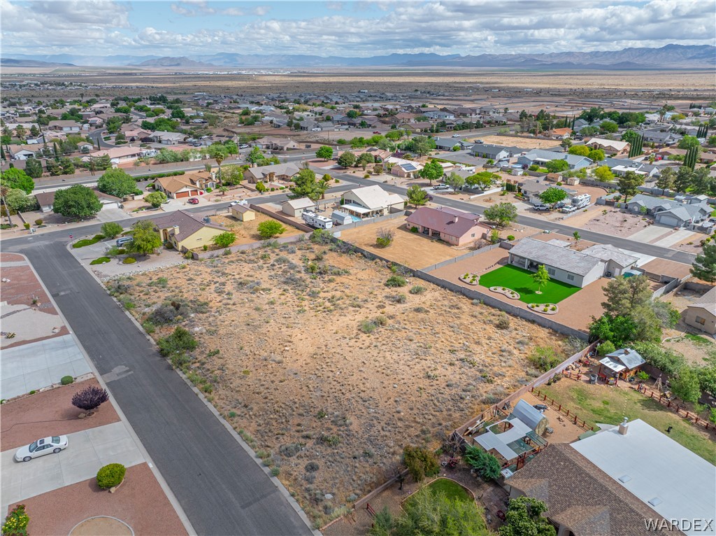 1400 Hidden Canyon Road Kingman, AZ 86401 - Photo 15 of 20 This aerial view showcases a spacious vacant lot, surrounded by an established residential neighborhood, with distant mountains providing a scenic backdrop