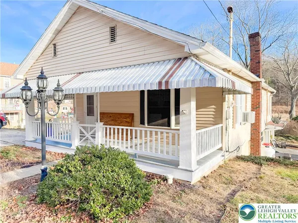 a view of a house with a small yard and wooden floor and fence
