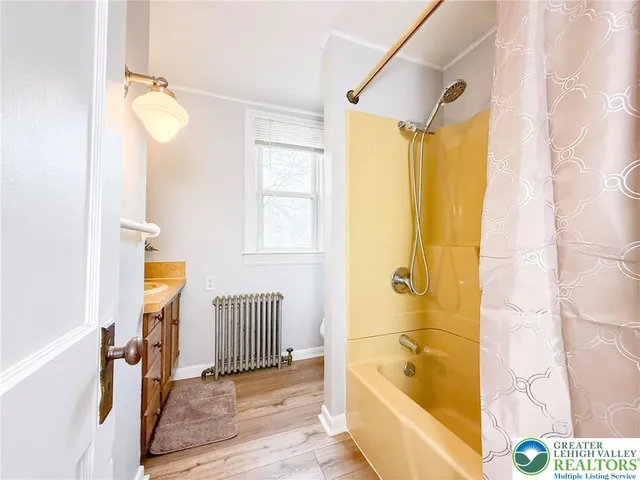 a bathroom with a tub shower and window
