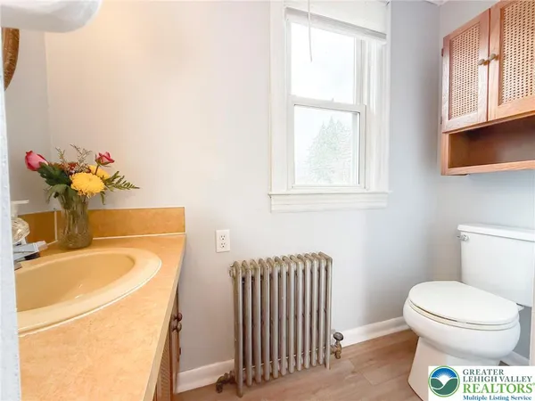 a bathroom with a sink toilet and a window