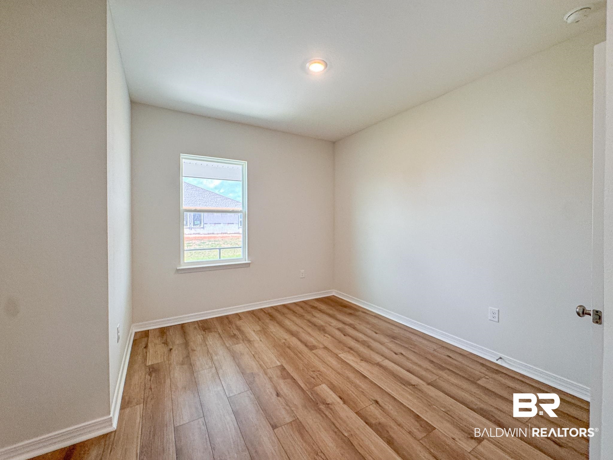 18151 Kent Circle Foley, AL 36535 - Photo 22 of 25 Spacious room featuring wood-finish flooring, a single window, recessed lighting, and crisp white trim