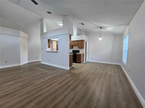 an empty room with wooden floor and window