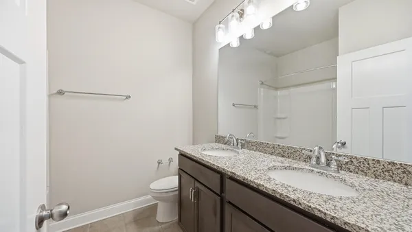 a bathroom with a granite countertop sink a toilet and a mirror