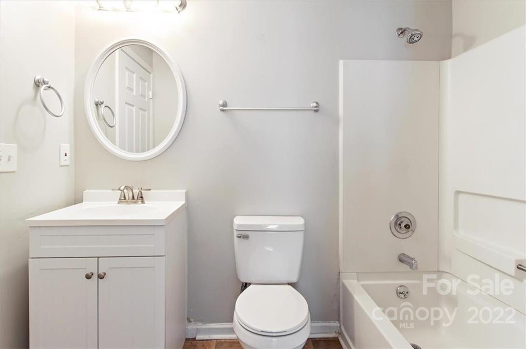 1235 Scaleybark Road, Unit E Charlotte, NC 28209 - Photo 20 of 23 a bathroom with a sink a toilet and a mirror