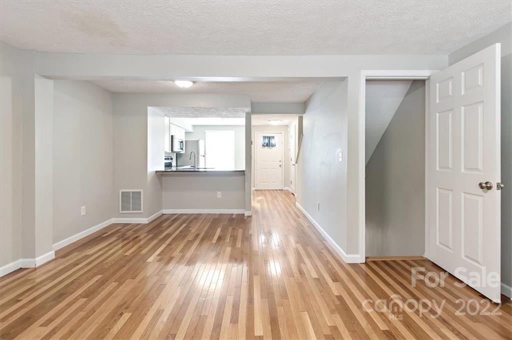 1235 Scaleybark Road, Unit E Charlotte, NC 28209 - Photo 9 of 23 a view of a room with wooden floor and a kitchen