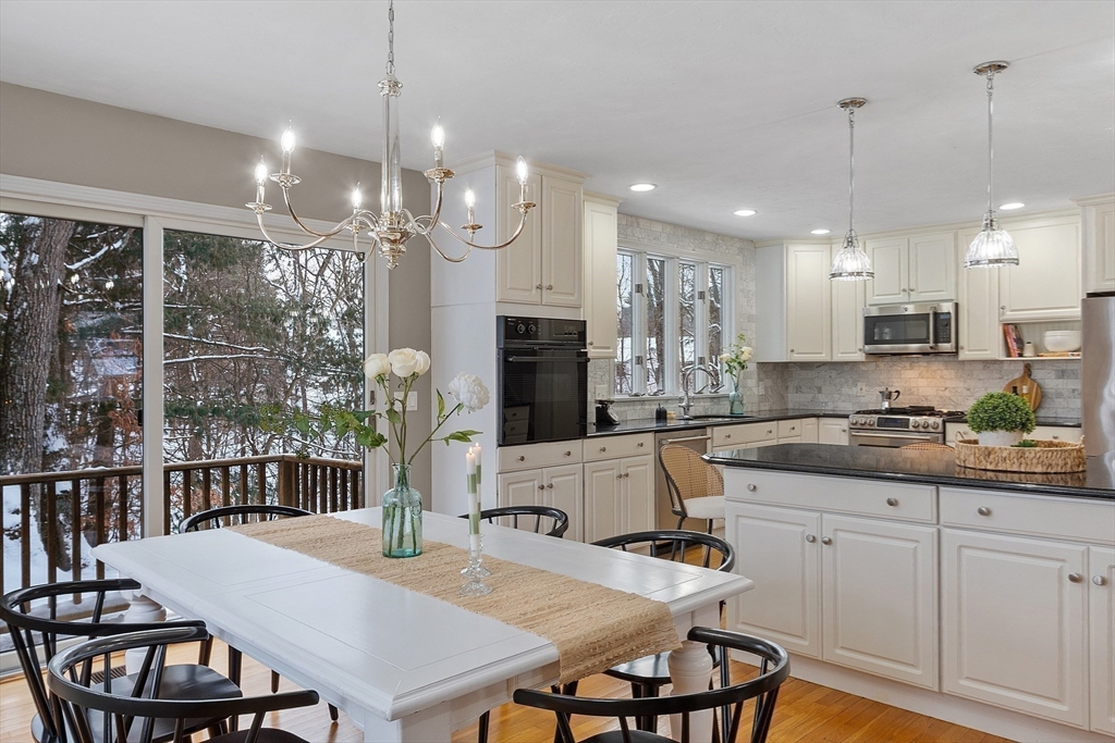 30 Duck Road Reading, MA 01867 - Photo 11 of 42 a kitchen with stainless steel appliances granite countertop a kitchen island a stove a table and chairs
