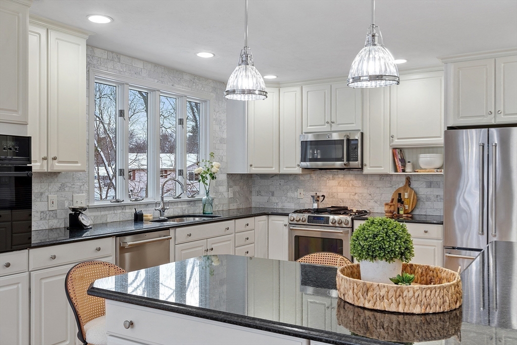 30 Duck Road Reading, MA 01867 - Photo 15 of 42 a kitchen with stainless steel appliances granite countertop a stove refrigerator and cabinets