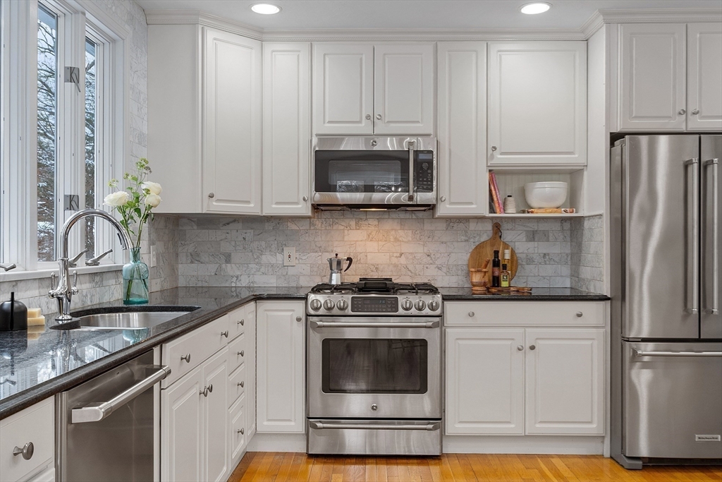 30 Duck Road Reading, MA 01867 - Photo 18 of 42 a kitchen with stainless steel appliances granite countertop a stove a refrigerator and a white cabinets