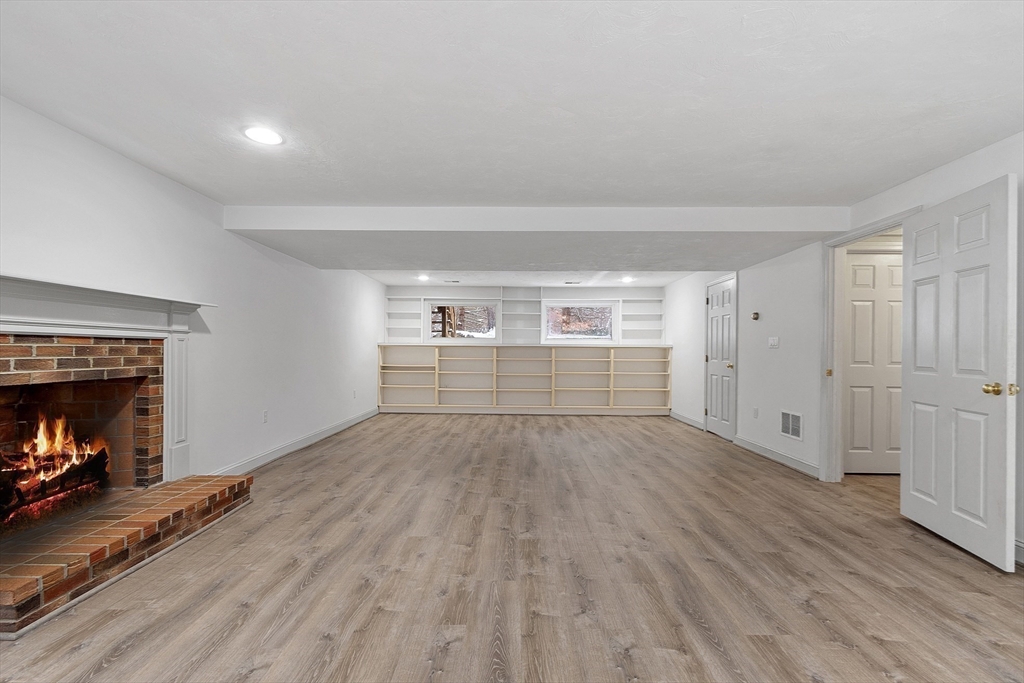 30 Duck Road Reading, MA 01867 - Photo 36 of 42 a view of empty room with wooden floor and fireplace